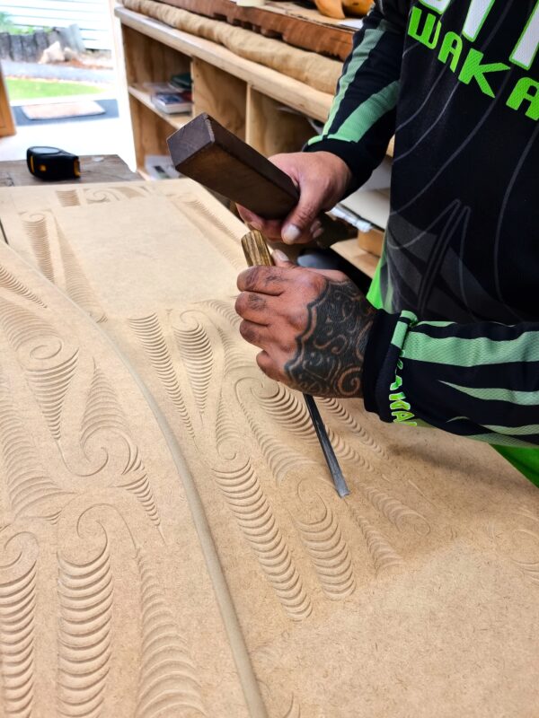 Carver at Pukaha carving out his puhoro pattern